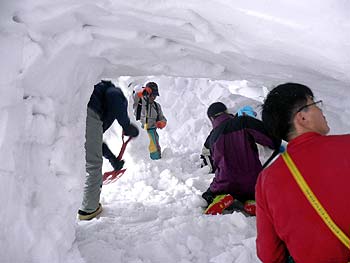雪洞を掘る救助隊員の様子
